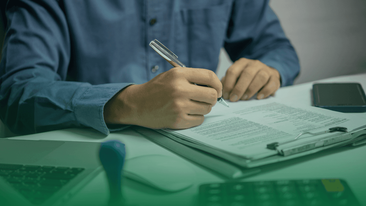 Homem verificando uma regulação em uma prancheta. No seu entorno ferramentas de um profissional de compliance.