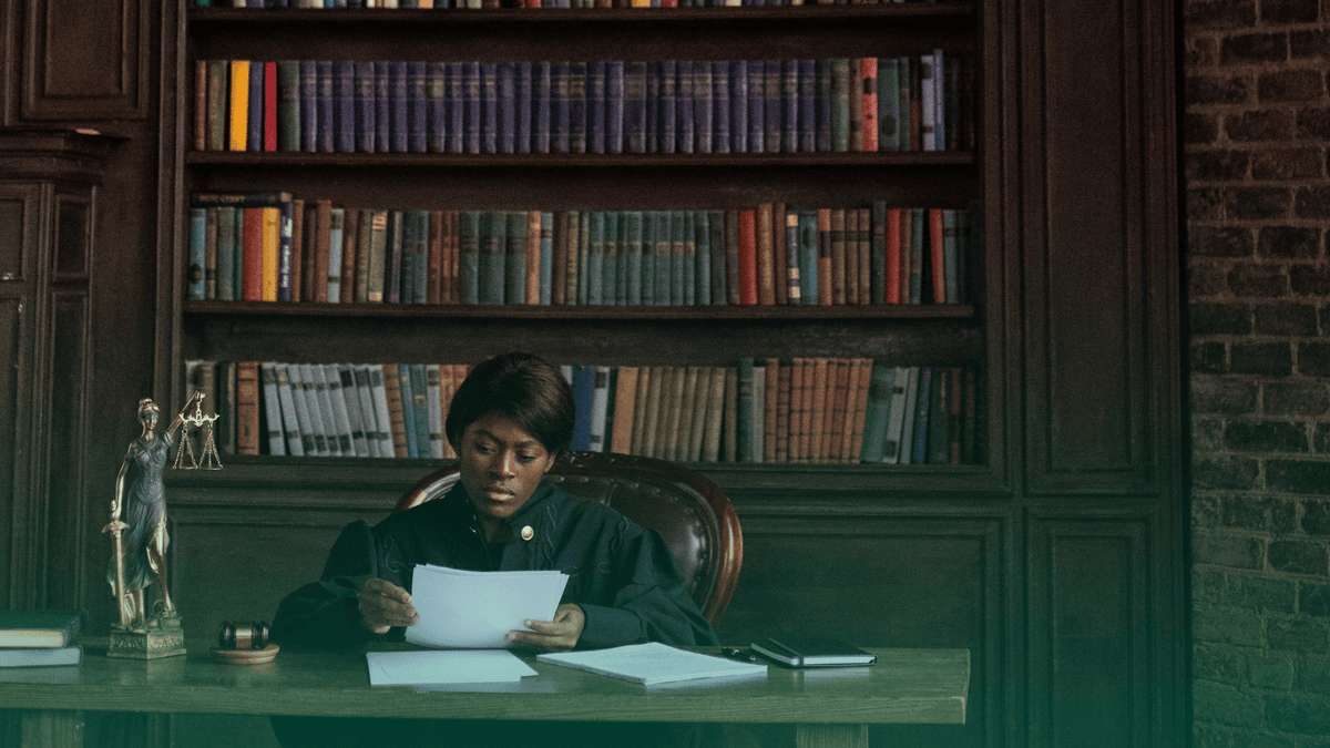 Mulher em um cenário jurídico, analisando documentos.